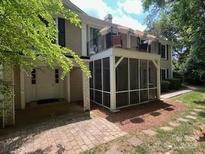 Charming townhouse featuring a screened porch and second-story balcony, surrounded by mature trees at 7026 Quail Hill Rd, Charlotte, NC 28210