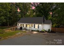 Inviting home exterior featuring a cozy porch swing, landscaped yard, and outdoor lighting for evening ambiance at 800 Woodlawn St, Belmont, NC 28012