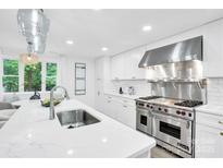 Bright kitchen with quartz countertops, white cabinets, stainless steel appliances, and stylish pendant lighting at 9826 Meringue Pl # 15, Charlotte, NC 28270