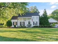 Charming white two-story home with rocking chair front porch and an American flag at 1020 12Th Nw Ave, Hickory, NC 28601
