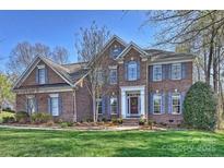 Charming two-story brick home with a manicured lawn and inviting front entrance at 15494 Donnington Dr, Charlotte, NC 28277
