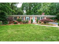 Charming brick ranch home with lush lawn, colorful landscaping, and covered parking at 1571 10Th Street Nw Pl, Hickory, NC 28601