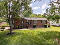 Charming brick home featuring a manicured lawn and mature trees at 1761 Arden Dr, Lincolnton, NC 28092