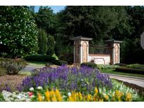 Stone entrance to Cheval community features manicured landscaping and flowering plants in a luxury neighborhood at 2408 Salute Blvd, Mint Hill, NC 28227