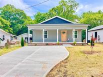 Charming gray home with a covered porch and a long concrete driveway at 251 Hall Nw Ave, Concord, NC 28027