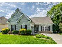 Charming single-story home boasts manicured lawn, fresh landscaping and a cozy, inviting facade on a bright, sunny day at 2598 Old Ashworth Nw Ln, Concord, NC 28027
