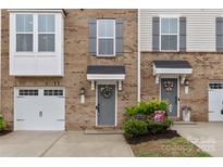 Charming brick townhome featuring a well maintained front yard and an attached garage at 416 Dalton Cir, Fort Mill, SC 29715