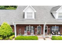 Charming brick home with a cozy front porch featuring rocking chairs and manicured landscaping at 556 Knighton Hill Rd, Rock Hill, SC 29732