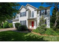 Charming two-story home with a manicured lawn and bright red front door at 8619 New Oak Ln, Huntersville, NC 28078