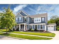 Charming two-story home with blue siding, well-manicured lawn, and attached two car garage at 10112 Andres Duany Dr, Huntersville, NC 28078