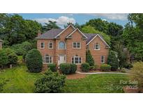 Elegant brick two-story home with arched windows and manicured landscaping on a lush, green lawn at 103 Samuel Guilford Ct, Charlotte, NC 28270