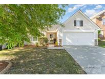 Charming single-Gathering home featuring a manicured lawn, attached garage, and welcoming front entrance at 13830 Riding Hill Ave, Charlotte, NC 28213