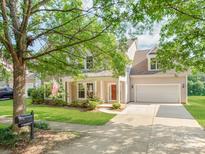 Inviting home featuring manicured lawn, mature trees, and an attached two car garage at 15001 Rosemary Way Dr, Huntersville, NC 28078