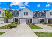 Charming townhome with a garage and a well-manicured front yard at 1563 Old Rivers Rd, Concord, NC 28027
