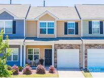 Charming townhome with a stone accent, attached garage, and cozy front porch seating area at 16039 Simril Ct, Charlotte, NC 28278