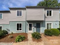 Charming townhome featuring light blue and gray siding, bright windows, and a welcoming front entrance with lovely landscaping at 1908 Harvest Ln # 5, Charlotte, NC 28210