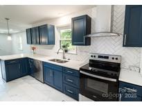This renovated kitchen showcases blue cabinets, quartz countertops, stainless appliances, and herringbone backsplash at 1936 Russell Ave, Charlotte, NC 28216