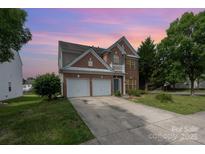 Charming brick two-story home featuring a two-car garage and a small balcony overlooking the front yard at 2013 Arbor Crest Ct, Charlotte, NC 28262