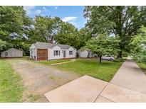 Charming single-story home featuring mature trees and a well-maintained lawn at 2601 Ashley Rd, Charlotte, NC 28208