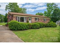 Charming brick home with a well-manicured lawn and lush landscaping, creating an inviting curb appeal at 3424 Autumn Dr, Gastonia, NC 28056