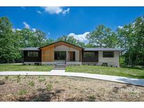 Inviting exterior showcasing a charming two-tone facade and well-maintained lawn at 5033 Waxhaw Indian Trail Rd, Matthews, NC 28104