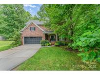 Charming two-story brick home with a well-manicured lawn and attached garage, offering curb appeal and convenience at 530 Shady Oaks Dr, Stanley, NC 28164