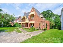 Charming brick Tudor-style home featuring unique architectural details and well-maintained landscaping at 611 E Marion St, Shelby, NC 28150