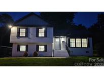 Charming two-story home with well-lit windows and a neatly landscaped front yard at twilight at 6328 Beecher Dr, Charlotte, NC 28215