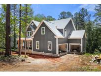 Two story home with gray siding, white trim and an attached two car garage in a wooded setting at 6782 Kingfisher Ct, Denver, NC 28037