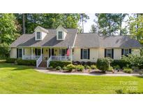 Charming home featuring a welcoming front porch, dormer windows, lush landscaping, and a well-maintained lawn at 785 Sanside Dr, York, SC 29745