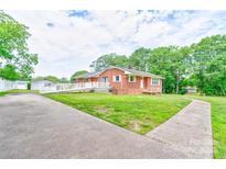 Charming single-story brick home with a ramp and a well-manicured lawn and mature trees at 800 Charles Rd, Shelby, NC 28150
