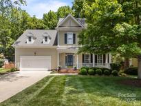 Charming two-story home featuring a manicured front yard and a welcoming front porch at 8441 Sandowne Ln, Huntersville, NC 28078