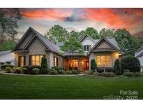 Charming brick home with lush landscaping, mature trees and a welcoming front entrance at 9002 Fair Oak Dr, Sherrills Ford, NC 28673