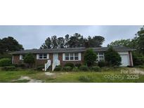 Charming brick home featuring a well-maintained lawn and mature trees in a quiet neighborhood at 116 E Graves St, Candor, NC 27229