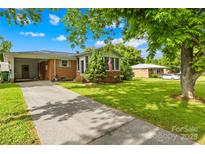 Charming brick home with a well-manicured lawn, mature trees, and a long driveway, offering a welcoming curb appeal at 119 Oak Ave, Shelby, NC 28152