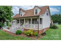 Charming home featuring a welcoming front porch, manicured landscaping, and classic architectural details at 139 Pleasant Garden Dr, Taylorsville, NC 28681