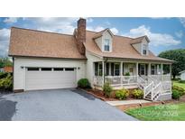 Inviting home with an attached garage, classic curb appeal, and a charming front porch at 139 Pleasant Garden Dr, Taylorsville, NC 28681