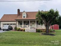 Charming single-Gathering home with a welcoming front porch, lush lawn, and attached garage at 139 Pleasant Garden Dr, Taylorsville, NC 28681
