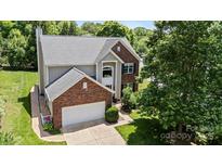 Charming two-story home with brick and siding exterior, attached garage, and mature landscaping at 16018 Hollingbourne Rd, Huntersville, NC 28078