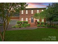 Charming brick two-story home featuring a well-manicured lawn and inviting front entrance at 16028 Cranleigh Dr, Huntersville, NC 28078