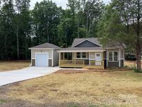 Charming home with a covered porch and a detached garage on a neatly mulched lawn at 1987 Robert Rufty Ln, Catawba, NC 28609