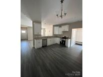 Bright kitchen features white cabinets, stainless steel appliances, and gray wood-look flooring at 1987 Robert Rufty Ln, Catawba, NC 28609