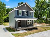 Charming two-story home with a welcoming front porch and beautifully landscaped surroundings at 210 N Correll St, Landis, NC 28025