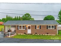 Charming brick home with a cozy covered porch and well-maintained front lawn at 2212 10Th Ne Ave, Hickory, NC 28601