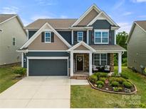 Beautiful two-story home with a manicured lawn, covered porch, and a two-car garage at 3009 Lydney Cir, Waxhaw, NC 28173