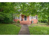 Charming brick home with a cozy front porch and well-maintained lawn at 411 Hanna St, Gastonia, NC 28052