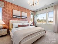A primary bedroom suite boasts natural light, stylish wallpaper, and elegant decorative touches at 5508 Swaling St, Charlotte, NC 28217