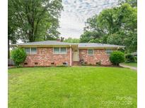Charming single-story brick home featuring a lush green lawn and mature trees at 5629 Ruth Dr, Charlotte, NC 28215