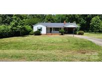 Charming single-story home with a well-manicured lawn and mature trees at 8000 Chapman St, Charlotte, NC 28216