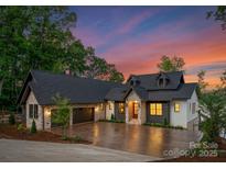 Stunning home showcasing stone and siding, a well-manicured lawn, and a spacious driveway leading to a two-car garage at 8066 Edgewater Dr # 103, Norwood, NC 28128